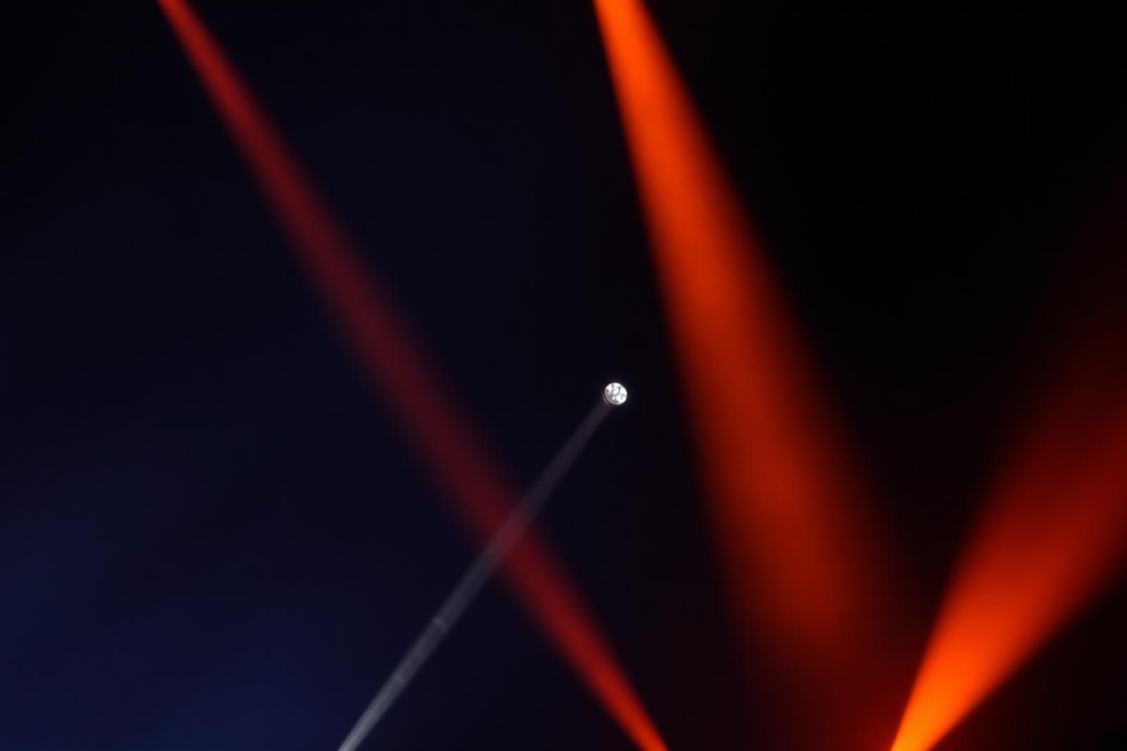 Moving-Head-Scheinwerfer mit orangefarbenen Lichtstrahlen im Nebel